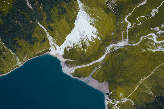 Landschaft Landschaft mit Wasser, grüner Wiese und Schnee